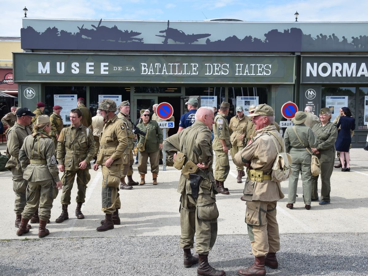 Un groupe d'hommes en uniformes militaires se tiennent devant un musée.