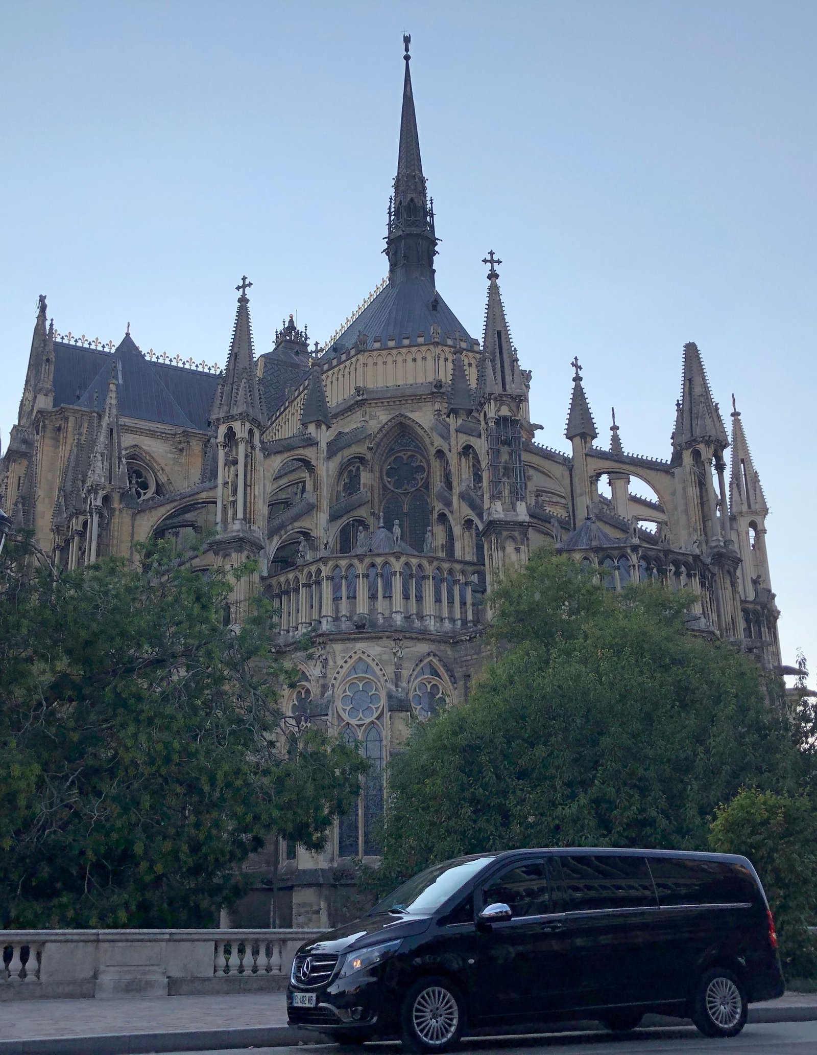 Une camionnette noire est garée devant un grand bâtiment.
