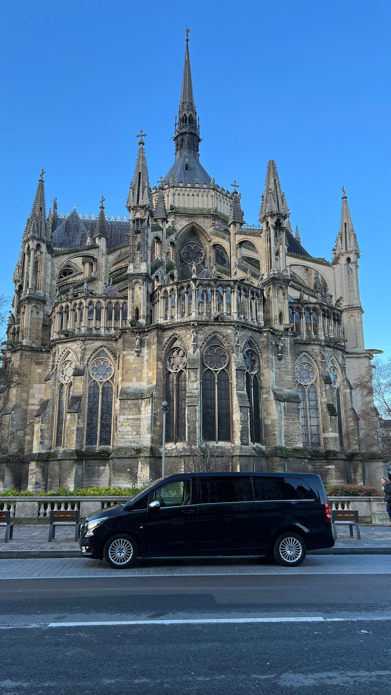Une camionnette noire est garée devant une grande église.