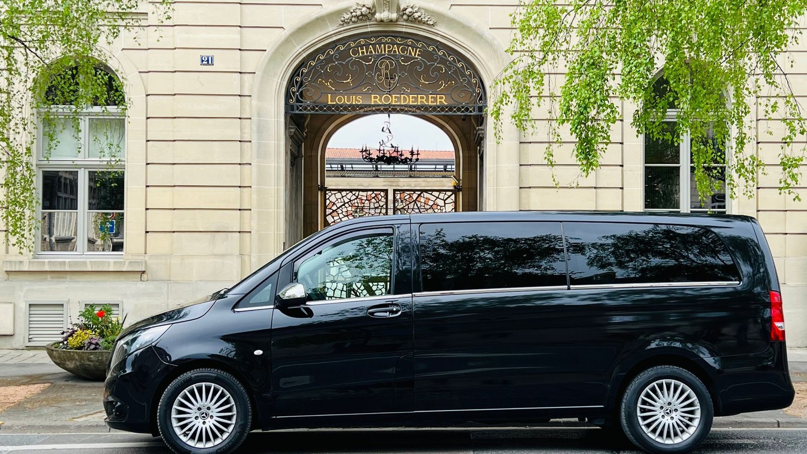 Une camionnette noire est garée devant un immeuble.
