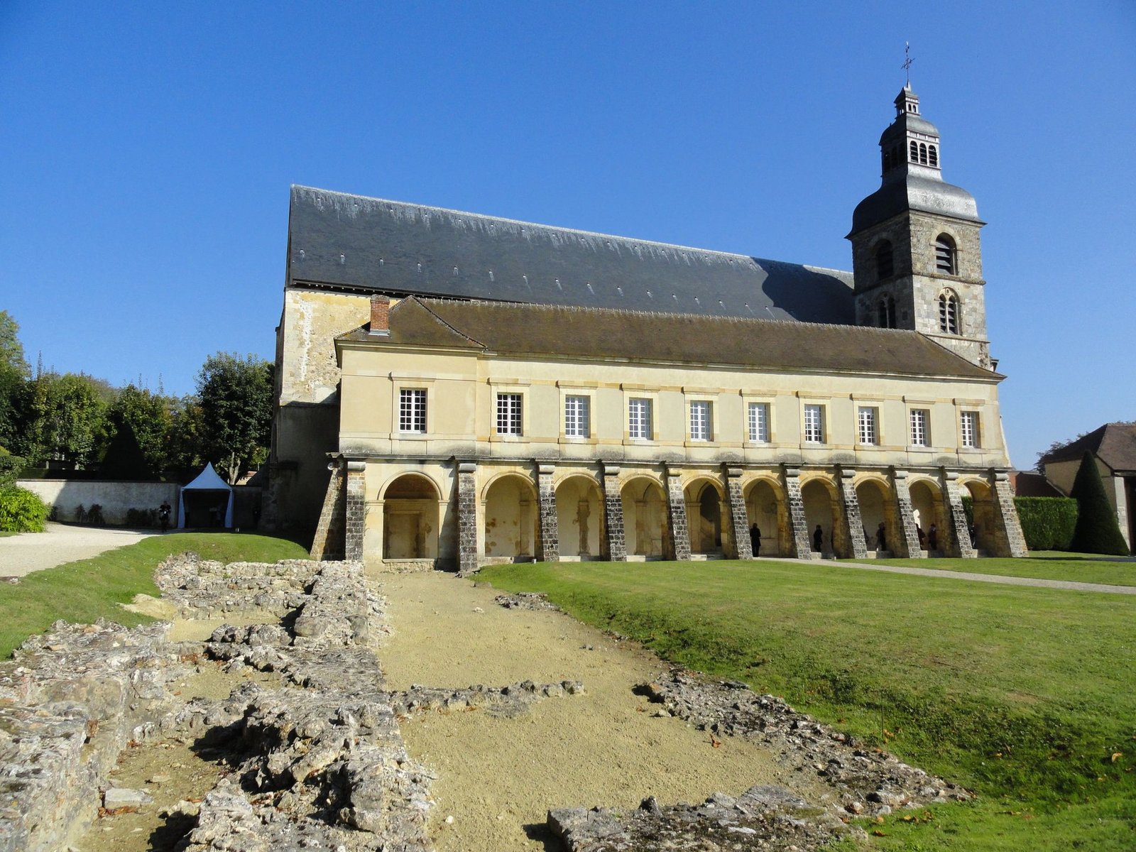 Un grand bâtiment avec des arches et une tour en arrière-plan