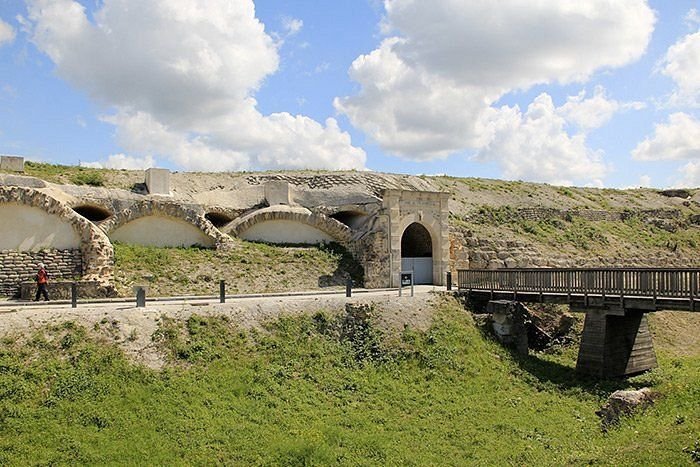Un pont sur une rivière avec un bâtiment en arrière-plan.