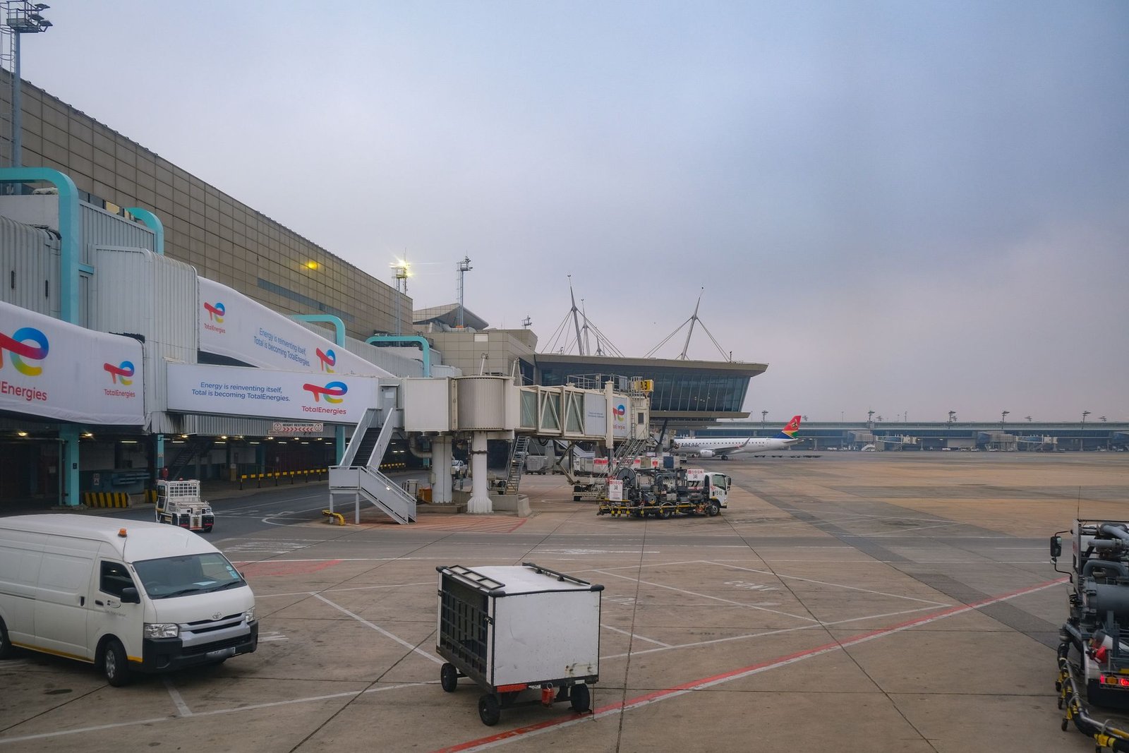 Une camionnette blanche est garée sur le tarmac d'un aéroport.